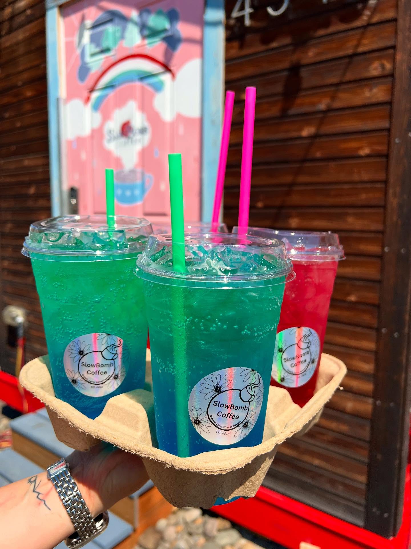 Vibrant neon green Slowbomb energy drink with colorful layers